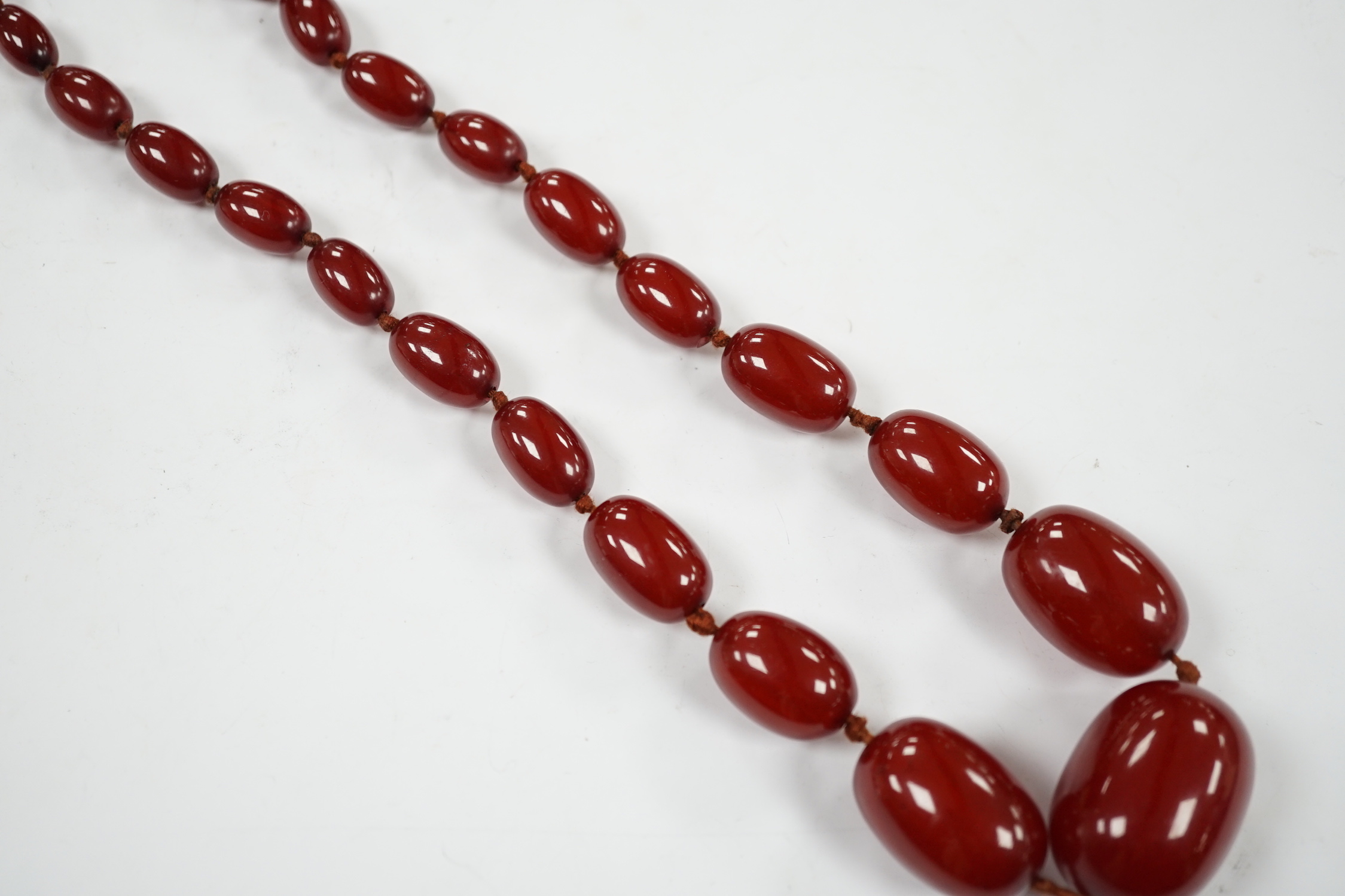 A single strand graduated simulated cherry amber necklace, 88cm, gross weight 74 grams.